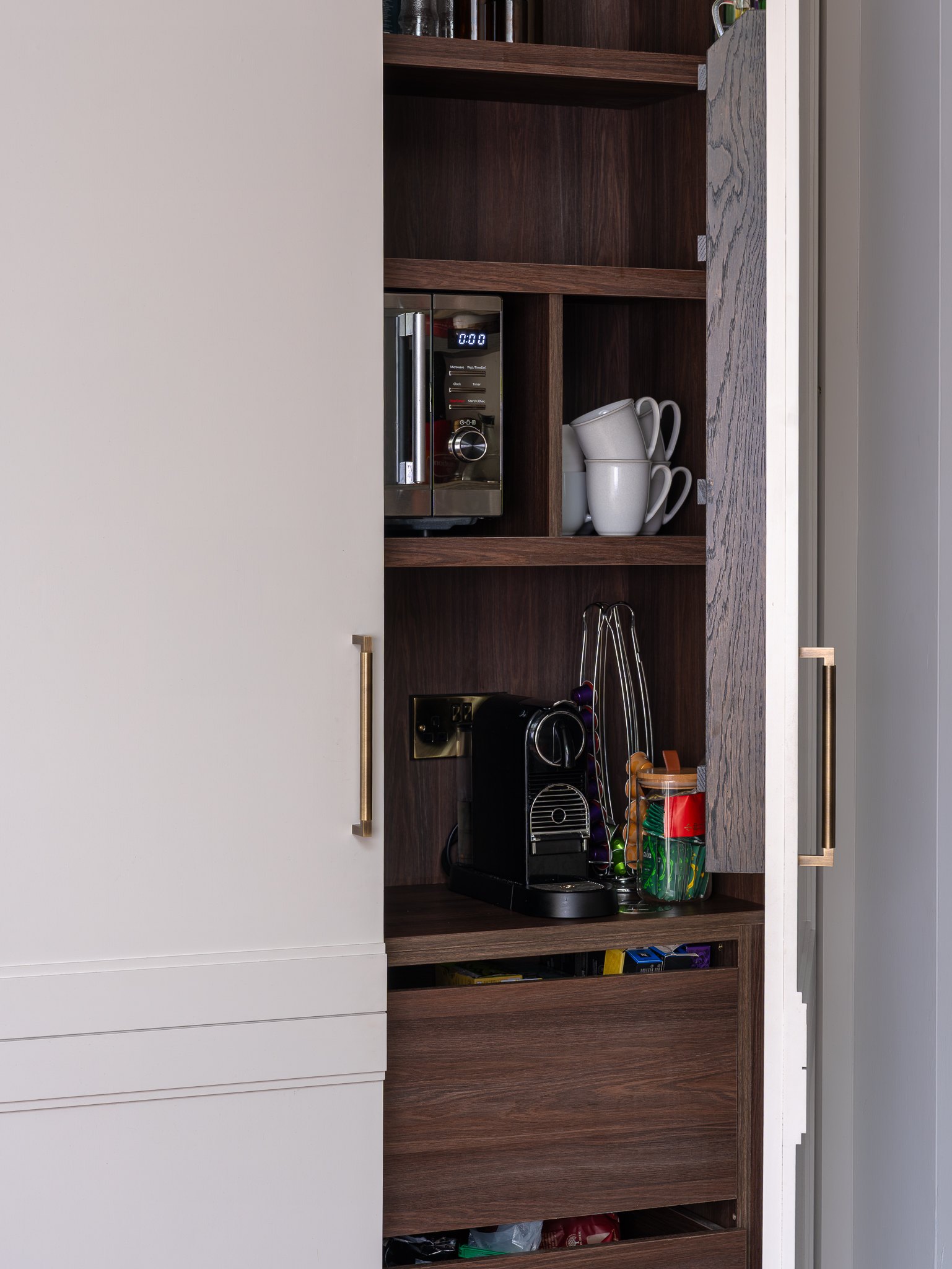 Bi-fold larder with dark stained oak internals and appliance station